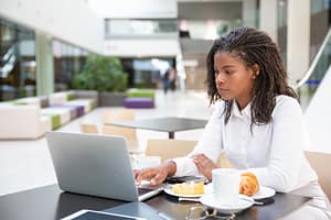 Serious young female professional working on project trying to make money online