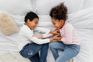 Children playing on the bed- managing sibling rivalry