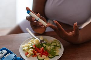 a person holding a device to test the blood sugar for the blog- what is diabetes