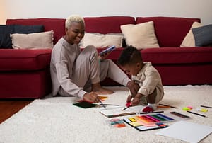 A woman and a child are sitting on the floor for the blog,- How to discipline your child with love.